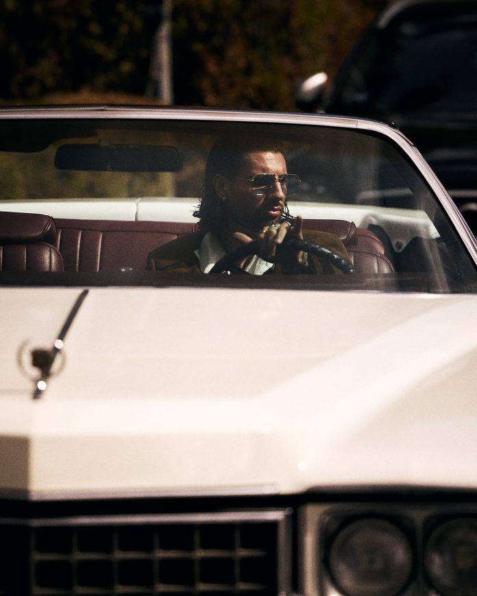A bordo de un Cadillac de 1970 y con un llamativo look: así llegó una figura del Liverpool a su país para disputar las fechas FIFA